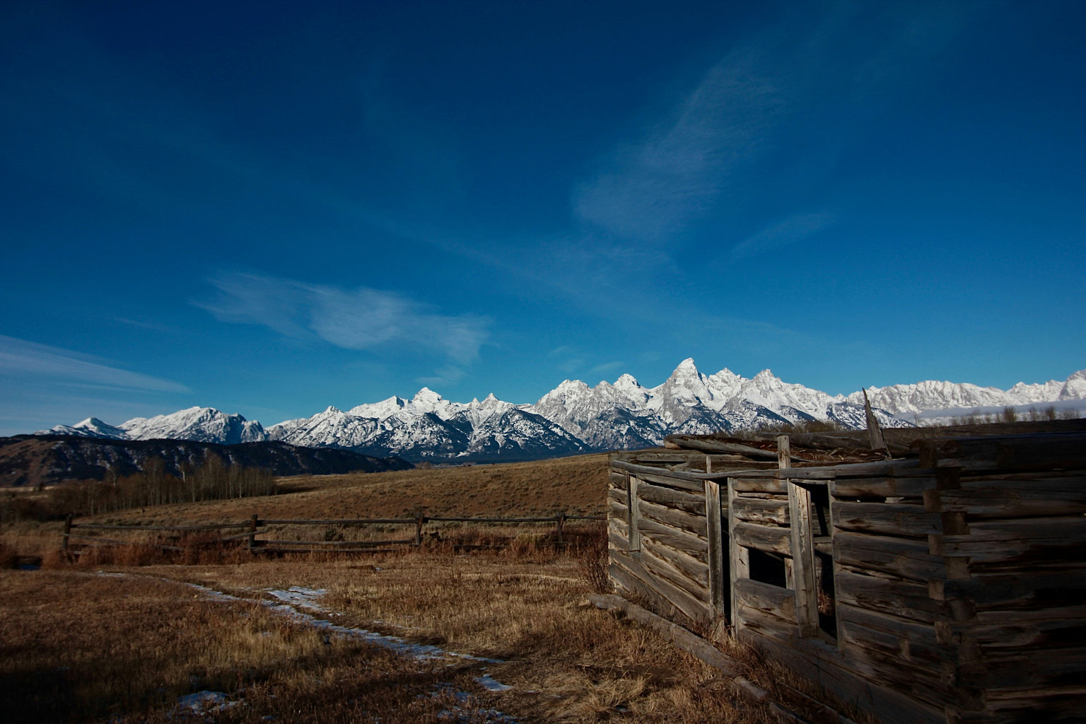 old log cabin white peaks in background